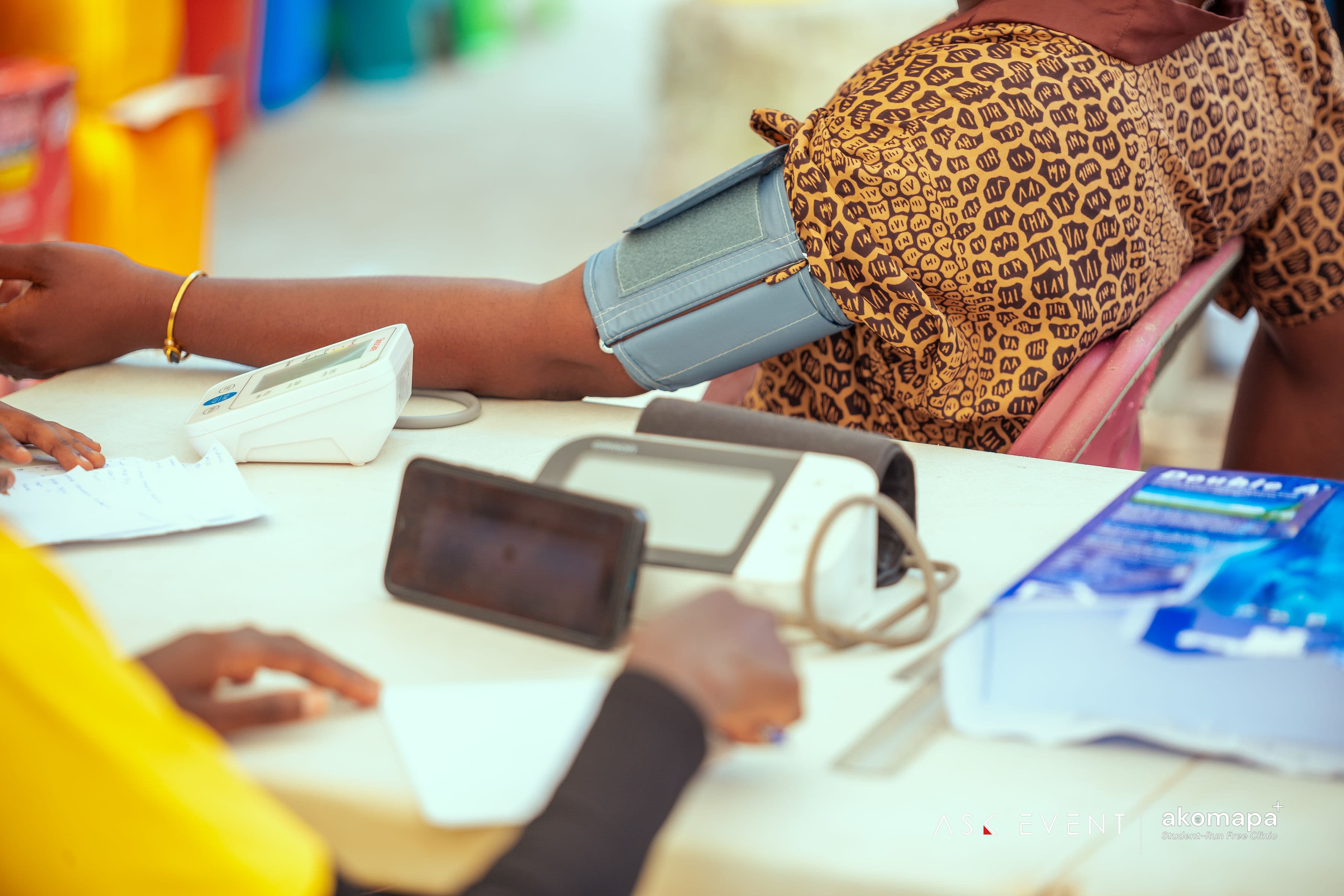 Close-up of blood pressure measurement with a digital monitor at a community health screening