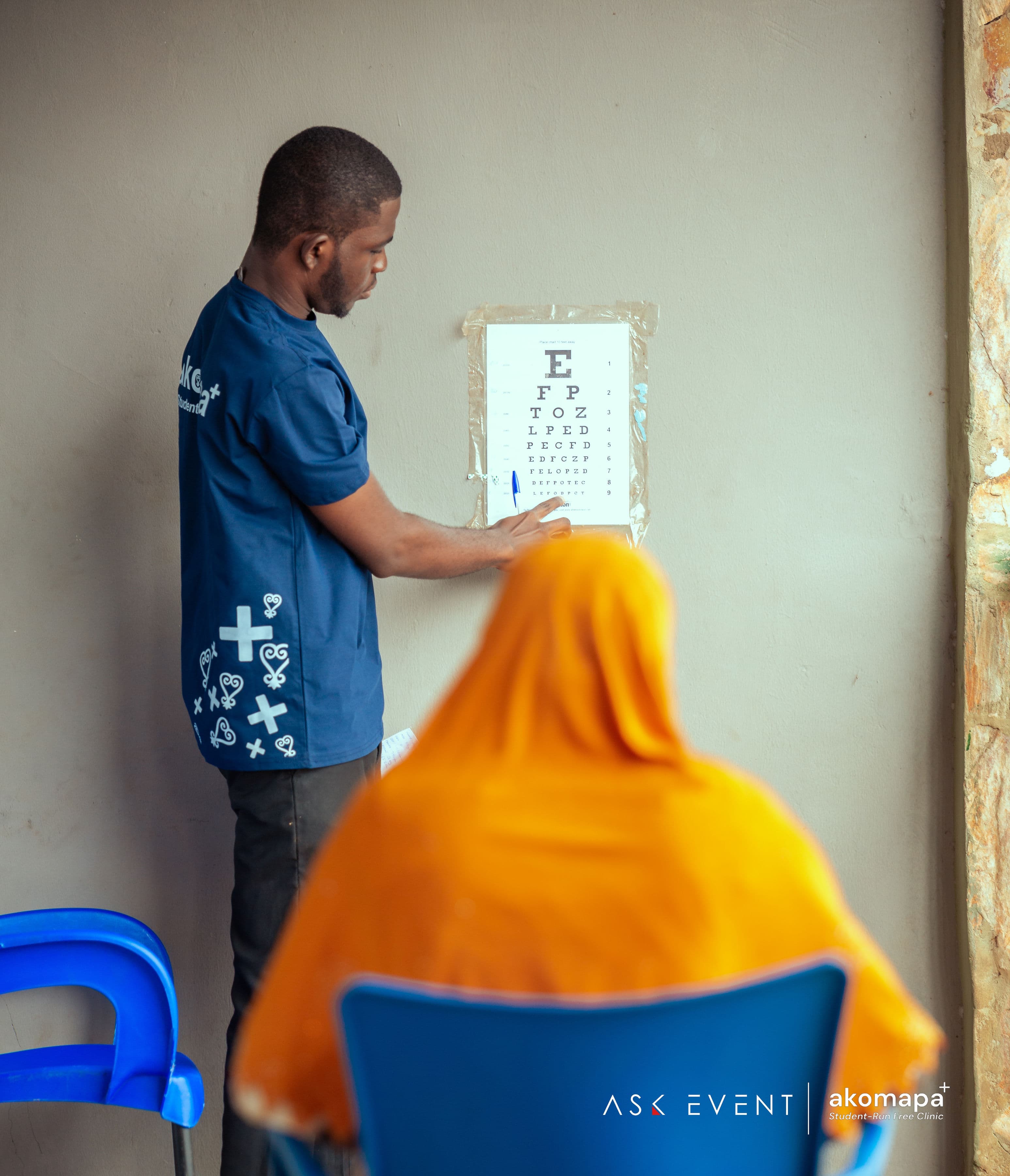 Akomapa volunteer conducting a vision screening with a Snellen eye chart